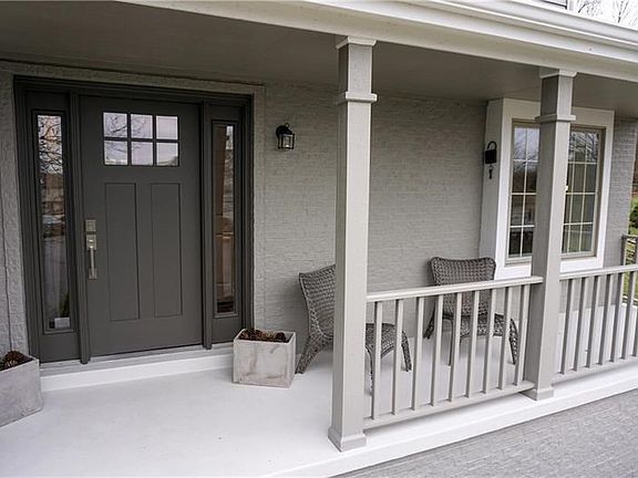 Greet guests on the covered porch of this custom brick home.  Enter into the home through the newer craftsman style door with br
