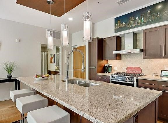 Spacious island illuminated by designer pendant lighting.