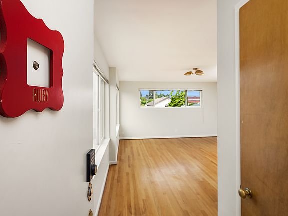 Welcome to Ruby! This corner unit, top floor apartment delights - with original oak hardwoods throughout, new mid century lighting and fresh paint from top to bottom. Easy commute to downtown and very walkable to Green Lake, PCC, bars and restaurants.