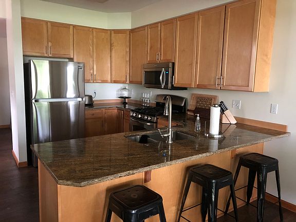 Granite counters, stainless appliances. Open to dining and living room . Floor to ceiling windows. View of willows and pond.