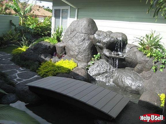 One of 2 waterfalls with lava rock boulders and stepping stones!
