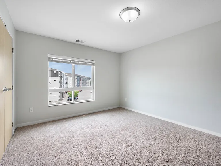 Bright and airy bedroom with a large window, carpeted floor, and neutral walls, ideal for personalization and comfort. Bright and airy bedroom with a large window, carpeted floor, and neutral walls, ideal for personalization and comfort.