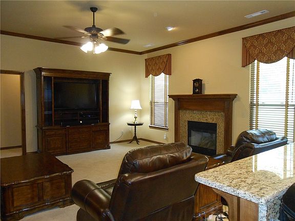 Fireplace, ceiling fan, large windows, and crown molding create a nice place to relax or entertain.