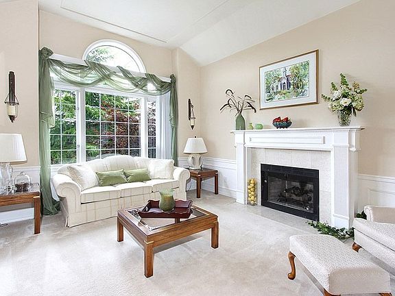 Step down into the living room which features cathedral ceilings, wainscoting, beautiful formal gas fireplace and impressive custom windows overlooking the territorial views and sunrises.