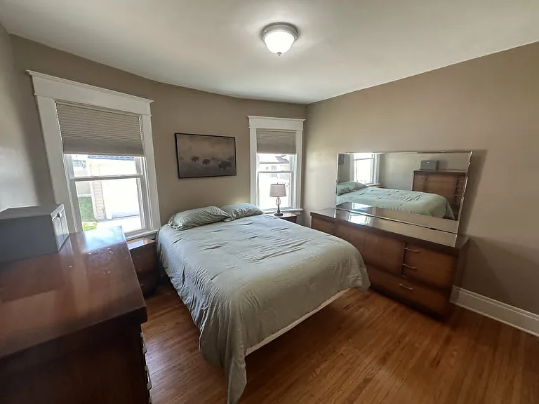 Large primary bedroom, fully furnished with a queen-size bed, dresser, and nightstands.