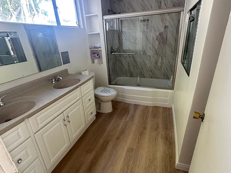 large bathroom with double sinks and large storage area