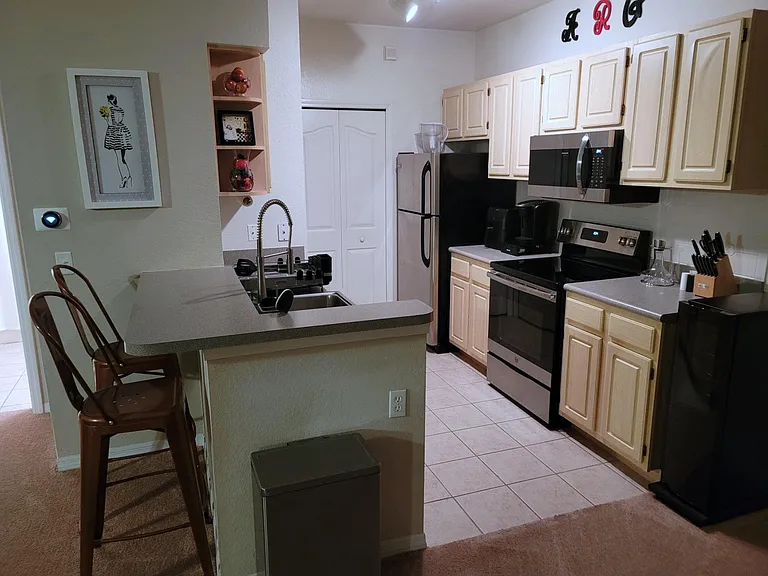 Nice kitchen with upgraded appliances with adjacent laundry room with washer, dryer & shelves.