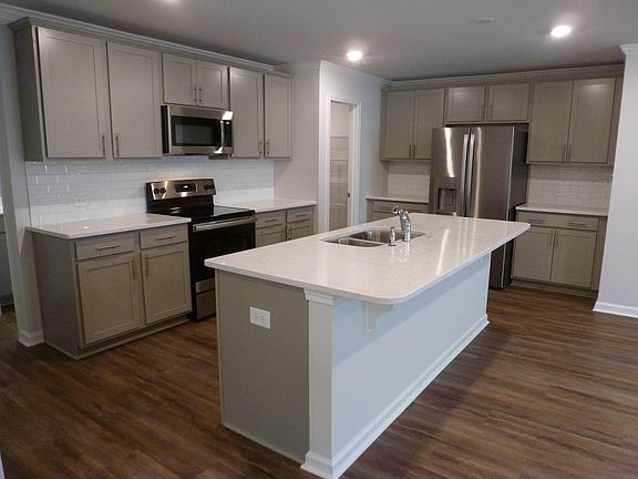 Upgraded Kitchen with Quartz Countertops, Island, SS Appliances and subway tile.