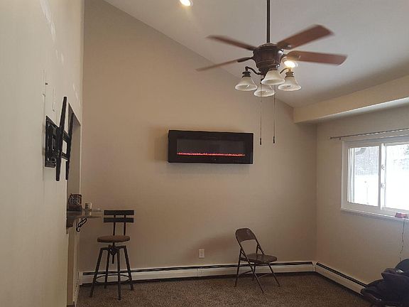 Living room with vaulted ceilings recessed lighting and wall mounted led color changing fireplace with remote control