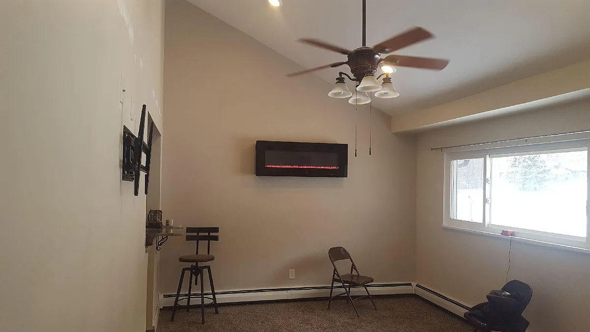 Living room with vaulted ceilings recessed lighting and wall mounted led color changing fireplace with remote control - 907 Coulter Rd