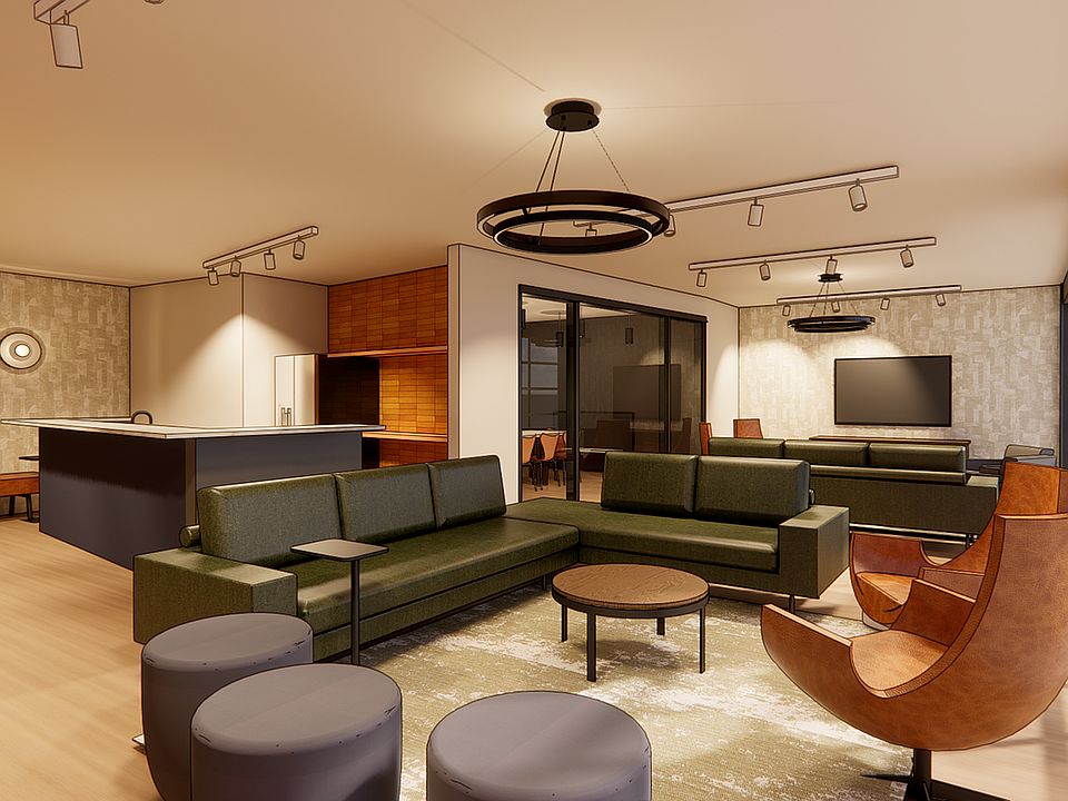 Modern open-concept rooftop clubroom with sleek green sectional, stylish leather chairs, and expansive windows.