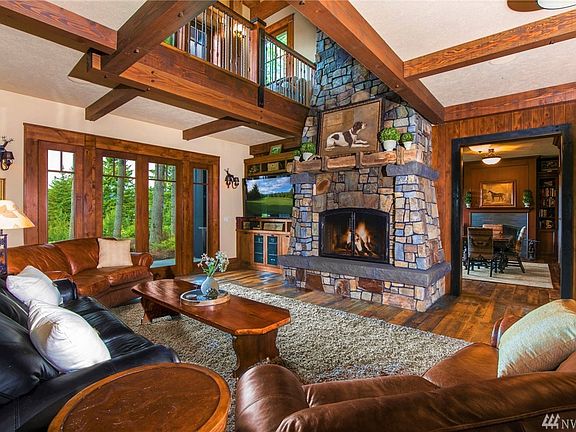 A Grand Two-Story Stone Fireplace Welcomes You, Upon Entry Into The Home.
