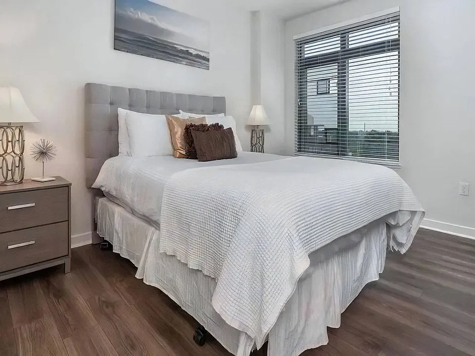 Apartment Bedroom Featuring Full-Size Bed and Hardwood Flooring