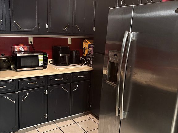 Kitchen with tile floor and 3 year old stainless steel appliances