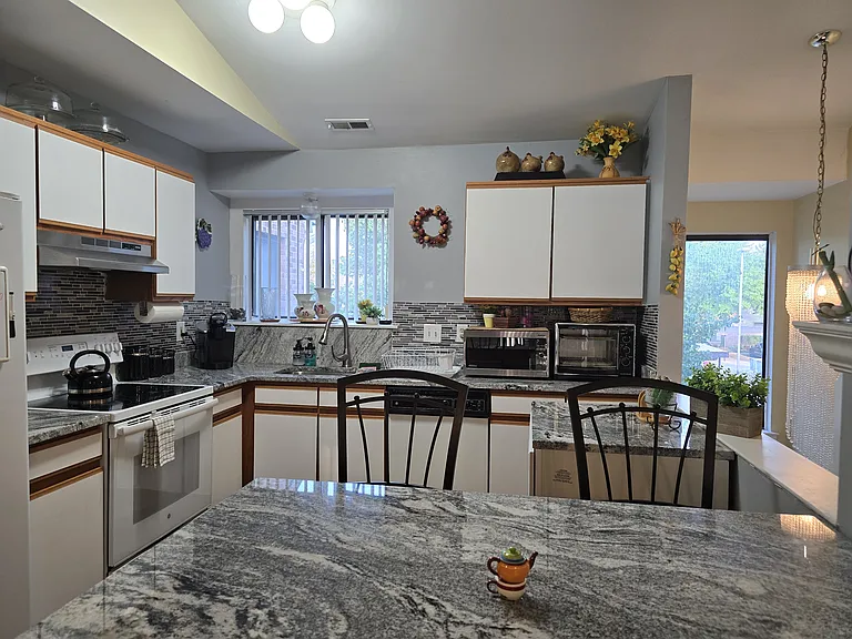 Kitchen has microwave, Toaster oven, coffee machine, fridge, and electric stove