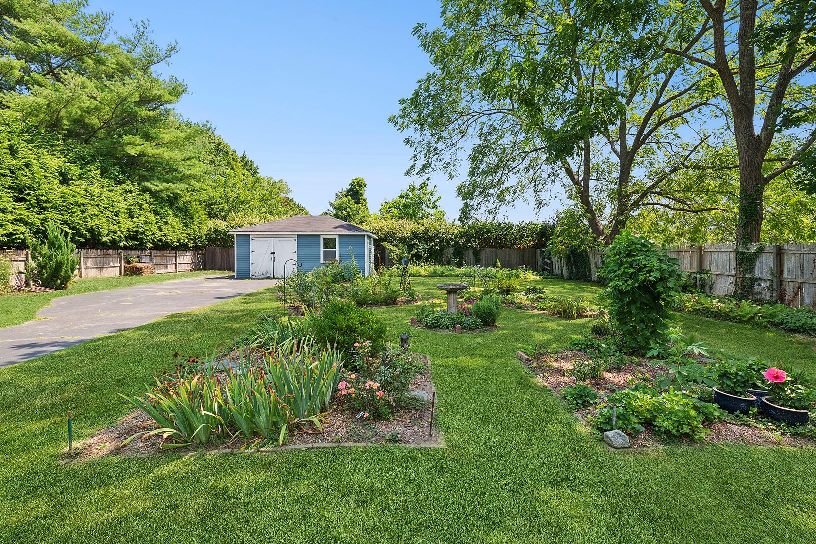 Well planted fenced in garden with barn style garage