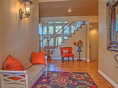 Entry with hardwood floors and elegant iron railing to lead one upstairs to the
