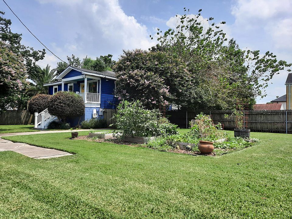Beautiful three-bedroom home with side lots and raised beds for the urban farmer!