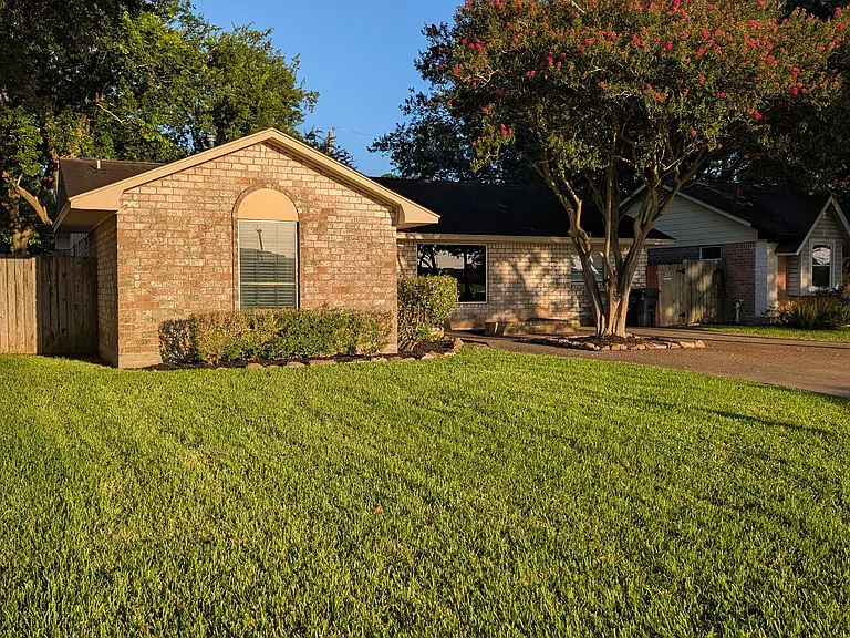 Steet scene captures the crepe myrtle with hedge landscape that welcomes one to the property.