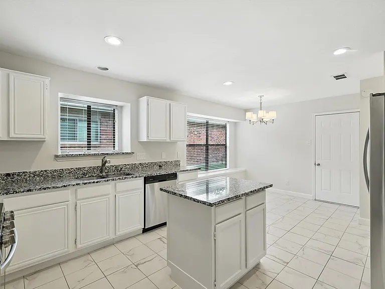 Large kitchen with stainless steel appliances; gas range