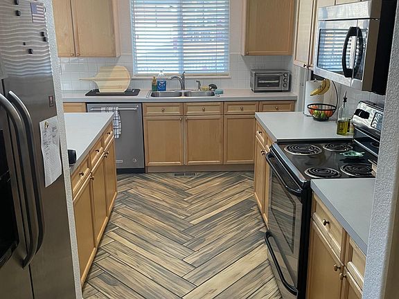Kitchen that has base cabinets, wall cabinets, counters, and other services located on both sides of a central walkway.