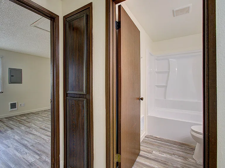 Hallway with built in storage, bathroom, and entrance to back bedroom