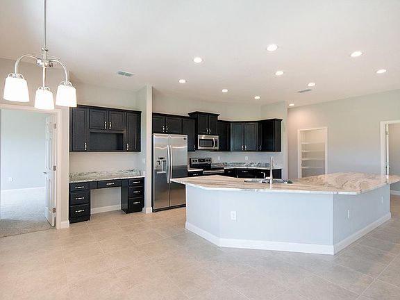 Beautiful open kitchen with a built-in desk, walk-in pantry, and your choice of finishes - Wynter by