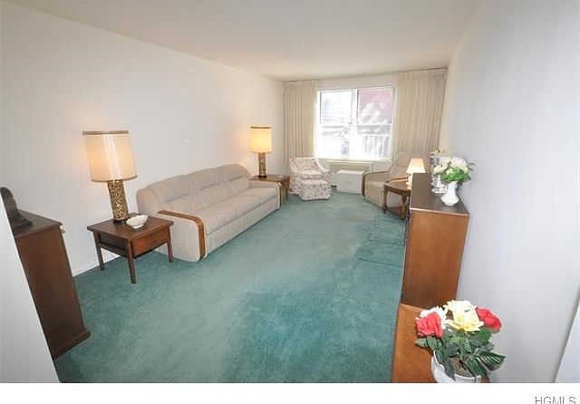 Bright and Sunny living room opens to the dining area. The room has covered hardwood floors.