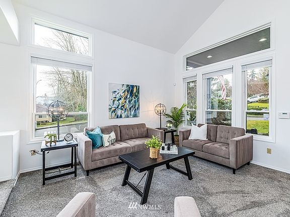 Step down formal living room with vaulted ceiling and lots of windows to let in the light.