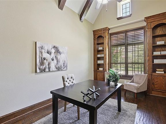 The warm study offers two walls of built in shelves (one in addition to these shown here), as well as a beamed ceiling, hand scraped wood floors, and plantation shutters.