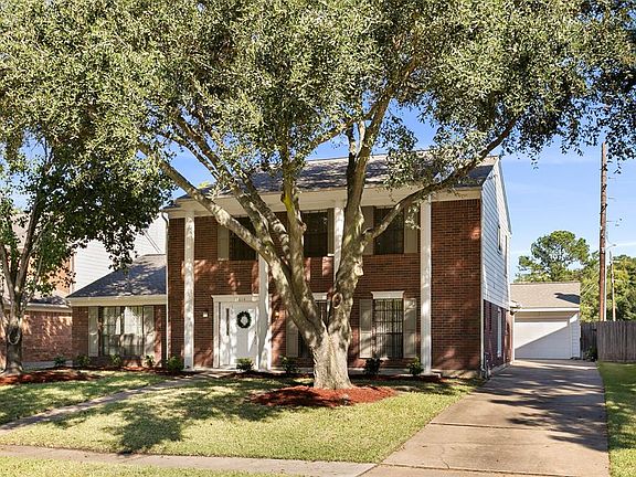 Long driveway leads to a 2 car detached garage with tons of storage, cabinets, peg board, flood lights and added lighting in the garage.