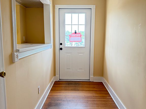 Bright, welcoming entry hallway with polished hardwood floors that lead straight to the storefront door, creating a smooth, professional flow for clients and staff.