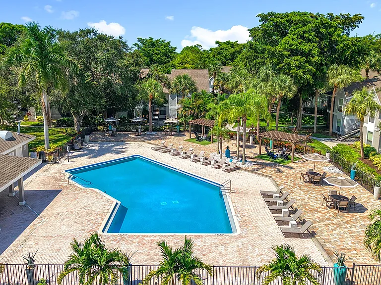Lounge in style beneath swaying palms at our beautifully maintained pool area, complete with seating, umbrellas, and a peaceful tropical vibe.