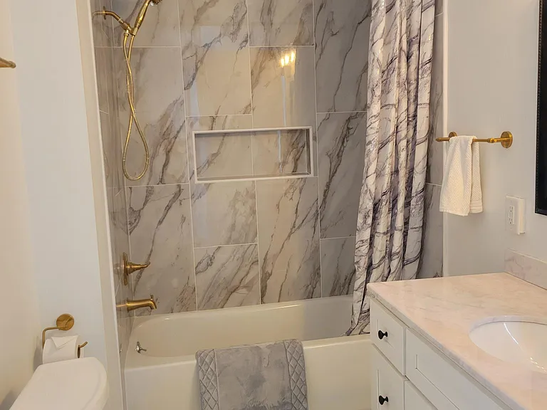Upstairs main full bathroom with large storage closet and access to attic