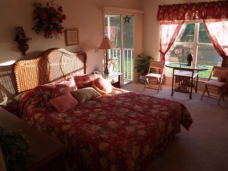 The sun streaking into the master bedroom with the queen size bed and cozy seating area both with a view of the water and sunsets.
Master bedroom has a walk in closet.