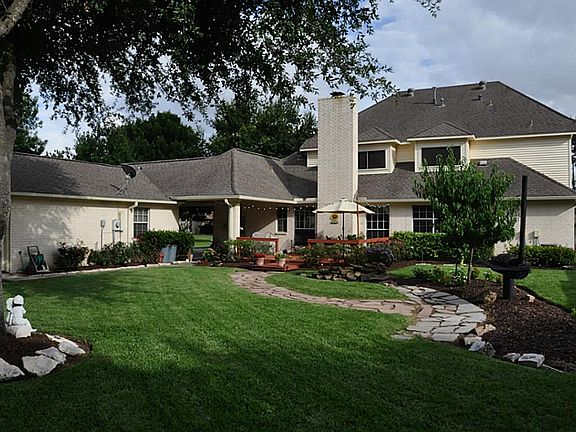 Large tranquil back yard with fountain/pond feature. Dog run behind the garage. A rose garden runs a