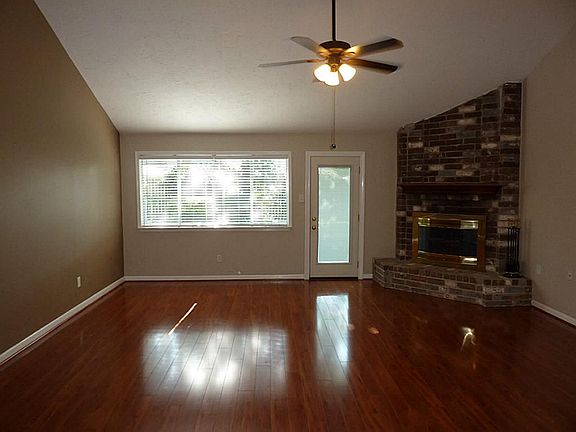 Living room with corner fireplace and door to back patio