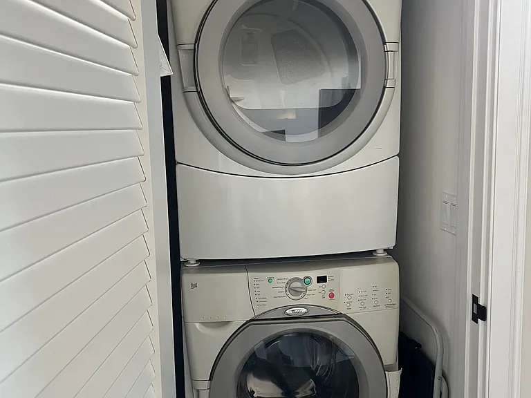 Laundry closet with stacked washer/dryer.