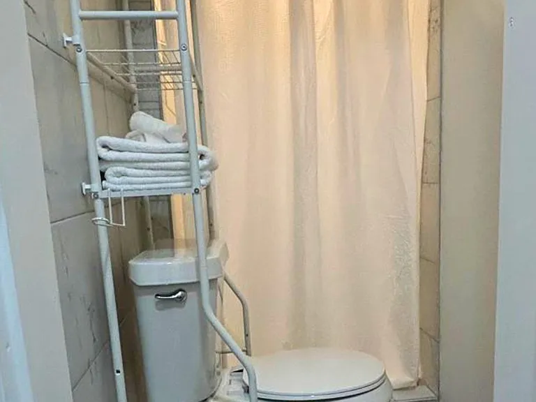 Bright, spacious bathroom with towel shelves and a roomy shower.