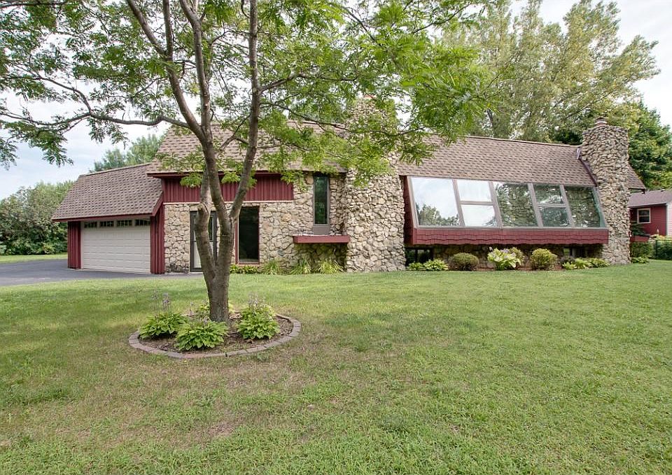 Awesome architectural styling on this ultra-unique home! A rich combination of glass, stone, wood and shingle details make for a commanding presence. 
Sweeping lawn and lush landscaping add to the visual appeal!