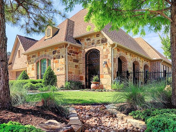 Another view of this lovely home and landscaping. Notice the open arches on the front porch entryway.
