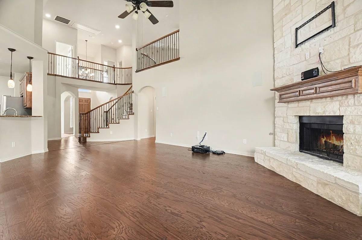 Expansive living area featuring wood-finish flooring and a stone fireplace with a substantial wooden mantel - 708 Yarrow St
