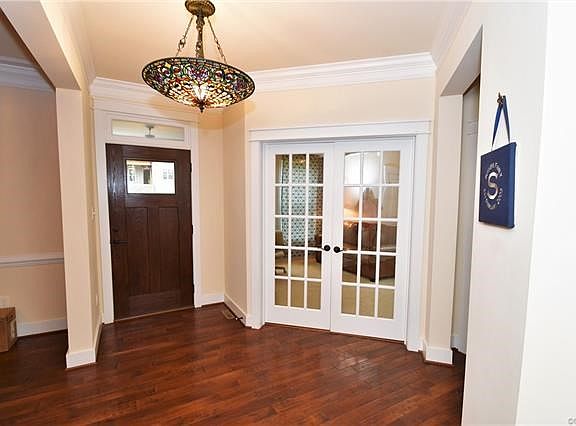 The foyer features beautiful hickory textured flooring, tiffany lighting and french doors leading to the office