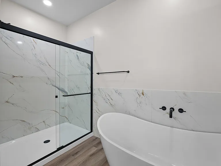 Primary en-suite bathroom's standing shower and standalone tub (3-bedroom floorplan)