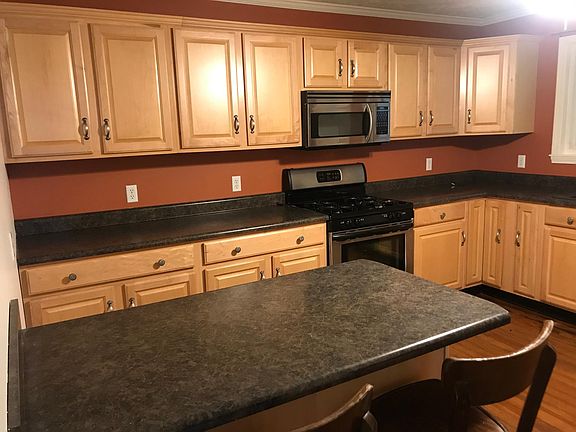 Kitchen with walnut cabinets and stainless appliances kit