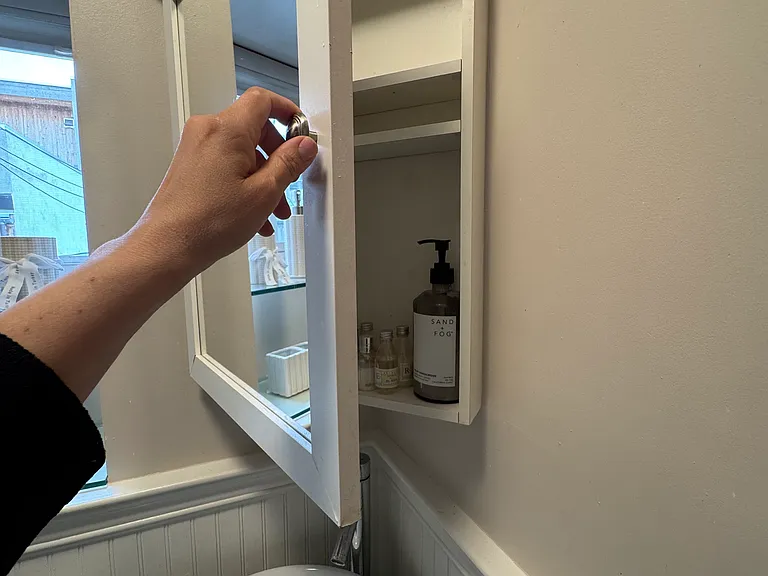 Bathroom mirrored cabinet with adjustable shelves.