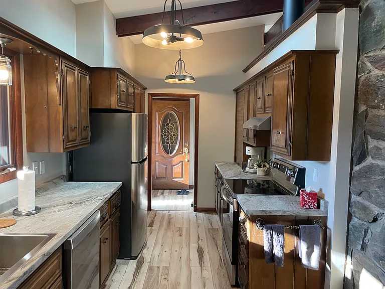 Kitchen to the right upon walking in (this picture shows this view with the front door open). Kitchen sink has large window facing the front yard.