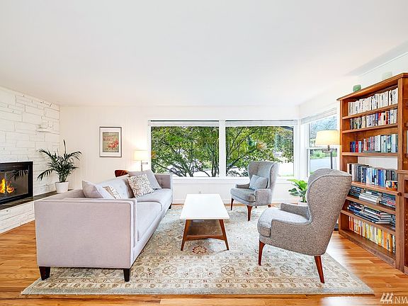 The large living room with beautiful hardwood floors, large picture window, and wood-burning fireplace is conveniently located off the dining room.