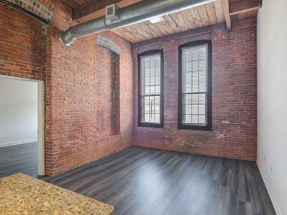 High ceilings, exposed brick, and vinyl flooring throughout. Large windows with lots of natural light.