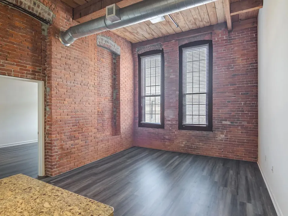 High ceilings, exposed brick, and vinyl flooring throughout. Large windows with lots of natural light.